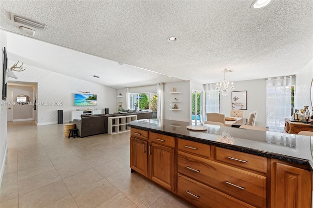 2421 NW 102nd Way, Pembroke Pines, FL 33026 - kitchen with open floor plan, a textured ceiling, brown cabinets, a chandelier, and light tile patterned floors