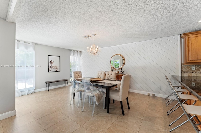 2421 NW 102nd Way, Pembroke Pines, FL 33026 - dining space with baseboards, a chandelier, light tile patterned floors, and a textured ceiling
