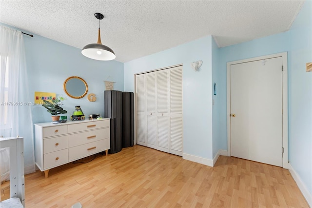 2421 NW 102nd Way, Pembroke Pines, FL 33026 - bedroom featuring light wood-style flooring, a textured ceiling, a closet, and baseboards