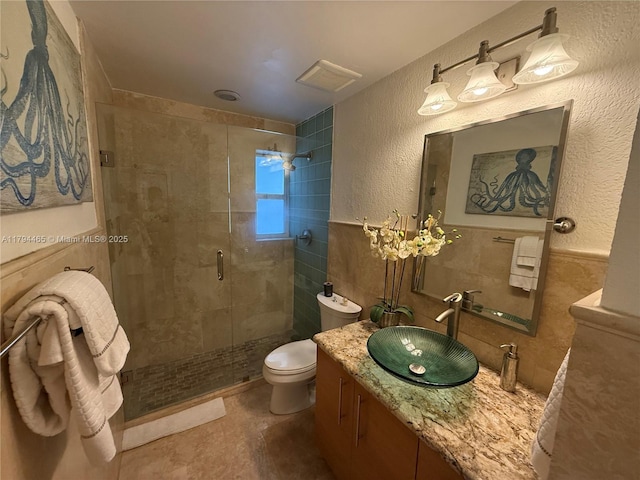 9720 SW 104th Ct, Miami, FL 33176 - full bathroom featuring tile walls, a stall shower, toilet, vanity, and a textured wall