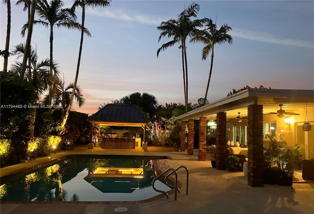 9720 SW 104th Ct, Miami, FL 33176 - pool at dusk with a gazebo, a ceiling fan, a patio, and an outdoor pool