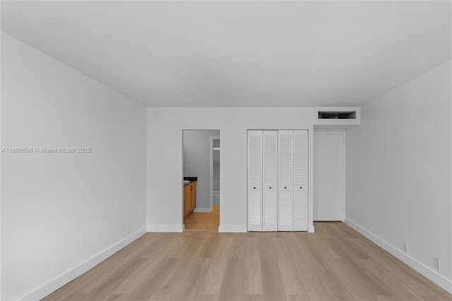 9511 Collins Ave Unit 806, Surfside, FL 33154 - unfurnished bedroom featuring light wood-style floors, baseboards, and a closet