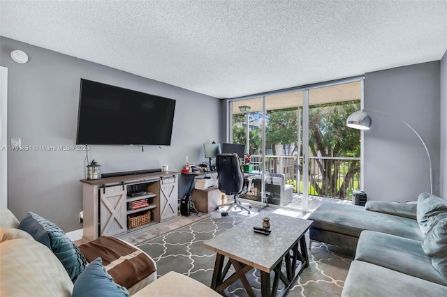living room featuring a wall of windows, an office area, and a textured ceiling