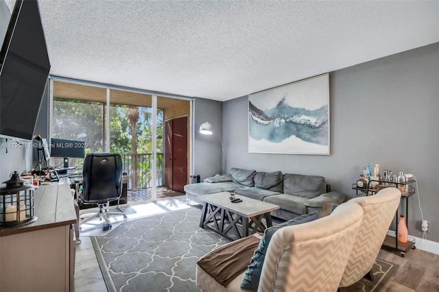 living room featuring expansive windows, a textured ceiling, an office area, wood finished floors, and baseboards