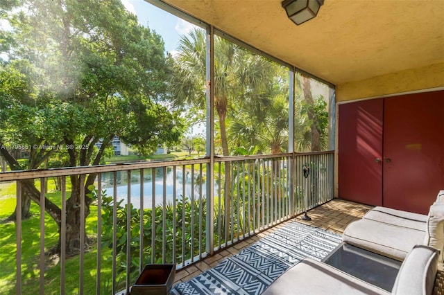 sunroom featuring a water view