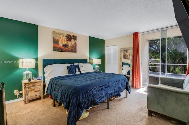 carpeted bedroom with access to exterior and a textured ceiling