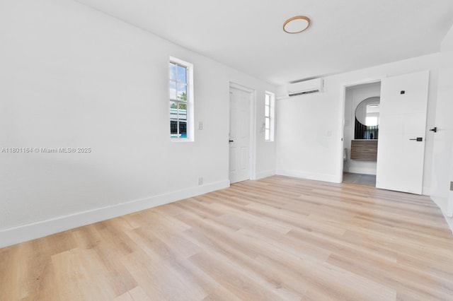 75 NW 125th St, North Miami, FL 33168 - unfurnished room with an AC wall unit, light wood finished floors, and baseboards