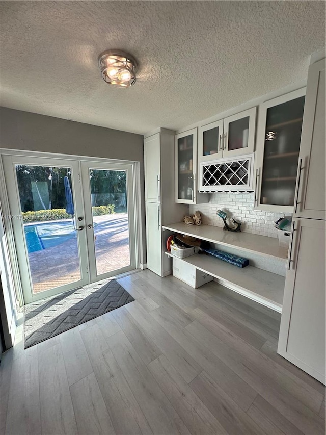 12821 SW 10th Ct, Davie, FL 33325 - bar area featuring wood finished floors, french doors, tasteful backsplash, and a textured ceiling