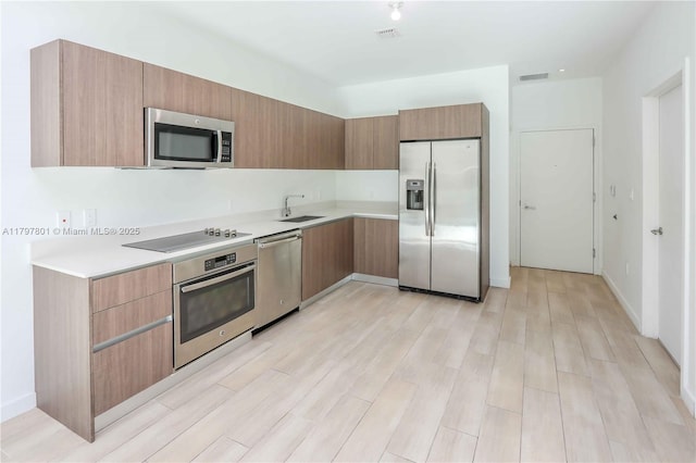 1600 SW 1st Ave Unit Th-07, Miami, FL 33129 - kitchen with stainless steel appliances, light countertops, a sink, light wood-style floors, and modern cabinets