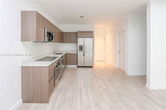 1600 SW 1st Ave Unit Th-07, Miami, FL 33129 - kitchen featuring stainless steel appliances, modern cabinets, a sink, light countertops, and light wood-type flooring