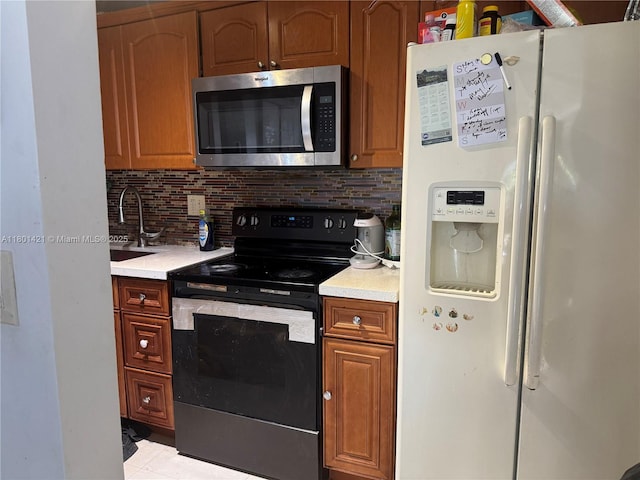4360 NW 79th Ave Unit 1F, Doral, FL 33166 - kitchen with white fridge with ice dispenser, stainless steel microwave, black electric range, light countertops, and backsplash
