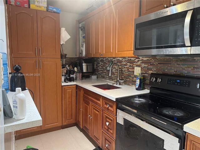 4360 NW 79th Ave Unit 1F, Doral, FL 33166 - kitchen with stainless steel microwave, electric range, tasteful backsplash, light countertops, and light tile patterned flooring