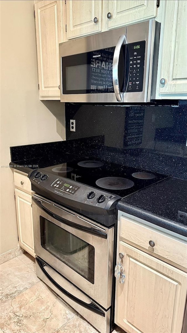 2665 SW 37th Ave Unit 1112, Miami, FL 33133 - kitchen with stainless steel appliances, light stone finish flooring, dark countertops, baseboards, and light brown cabinets