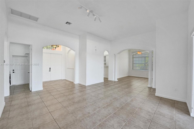 3360 SW 195th Ter, Miramar, FL 33029 - empty room with arched walkways, light tile patterned flooring, baseboards, and track lighting