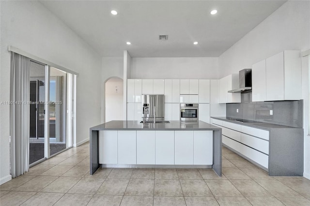 3360 SW 195th Ter, Miramar, FL 33029 - kitchen with appliances with stainless steel finishes, wall chimney exhaust hood, arched walkways, dark countertops, and white cabinetry