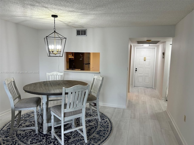 1000 Colony Point Cir Unit 302, Pembroke Pines, FL 33026 - dining space with light wood-type flooring, baseboards, a chandelier, and a textured ceiling