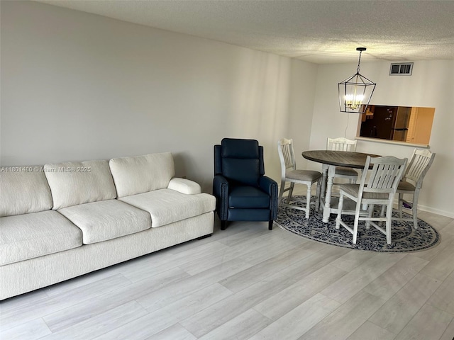 1000 Colony Point Cir Unit 302, Pembroke Pines, FL 33026 - living area with light wood finished floors, a chandelier, and a textured ceiling