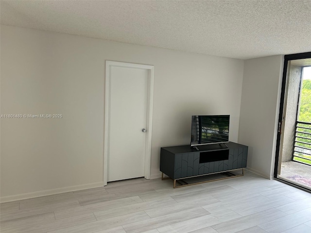 1000 Colony Point Cir Unit 302, Pembroke Pines, FL 33026 - living area with light wood finished floors, a textured ceiling, and baseboards