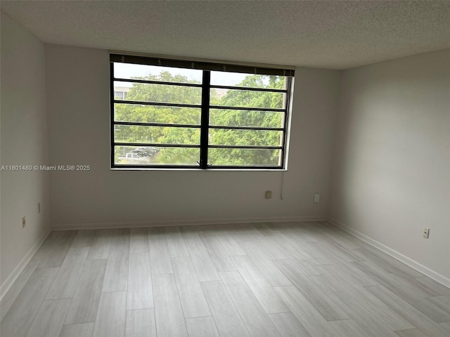 1000 Colony Point Cir Unit 302, Pembroke Pines, FL 33026 - unfurnished room featuring a textured ceiling, light wood-type flooring, and baseboards