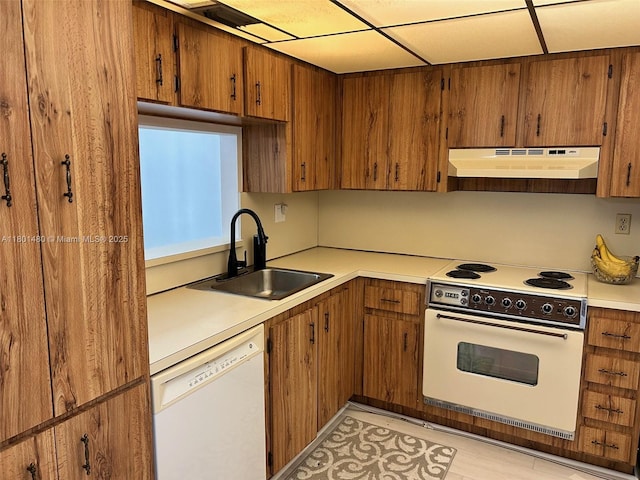 1000 Colony Point Cir Unit 302, Pembroke Pines, FL 33026 - kitchen featuring under cabinet range hood, white appliances, a sink, brown cabinetry, and light countertops
