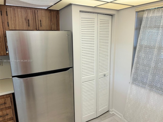 1000 Colony Point Cir Unit 302, Pembroke Pines, FL 33026 - kitchen with freestanding refrigerator, brown cabinets, baseboards, and light countertops