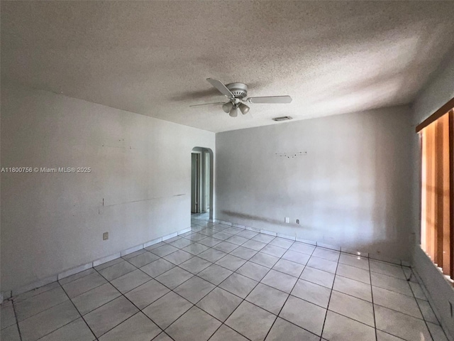 3035 NW 100th St, Miami, FL 33147 - unfurnished room featuring a ceiling fan, arched walkways, light tile patterned flooring, and a textured ceiling