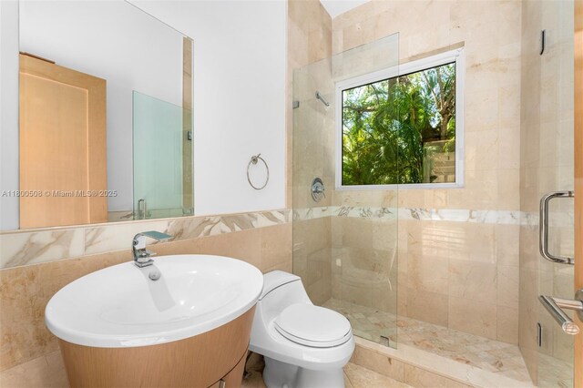 9500 SW 60th Ct, Pinecrest, FL 33156 - full bath with tile walls, a shower stall, toilet, a sink, and wainscoting