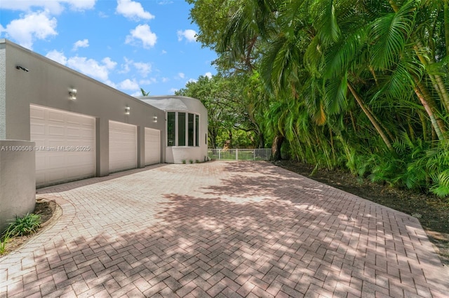 9500 SW 60th Ct, Pinecrest, FL 33156 - view of patio / terrace featuring decorative driveway, an attached garage, and fence