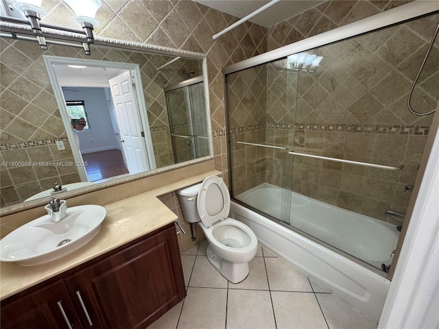 3500 Coral Way Unit 501, Miami, FL 33145 - bathroom featuring shower / bath combination with glass door, tile patterned flooring, vanity, toilet, and tile walls