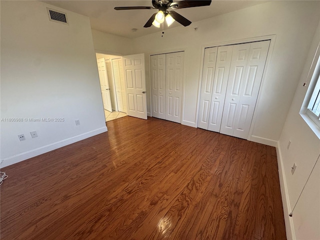 3500 Coral Way Unit 501, Miami, FL 33145 - unfurnished bedroom with baseboards, multiple closets, wood finished floors, and a ceiling fan
