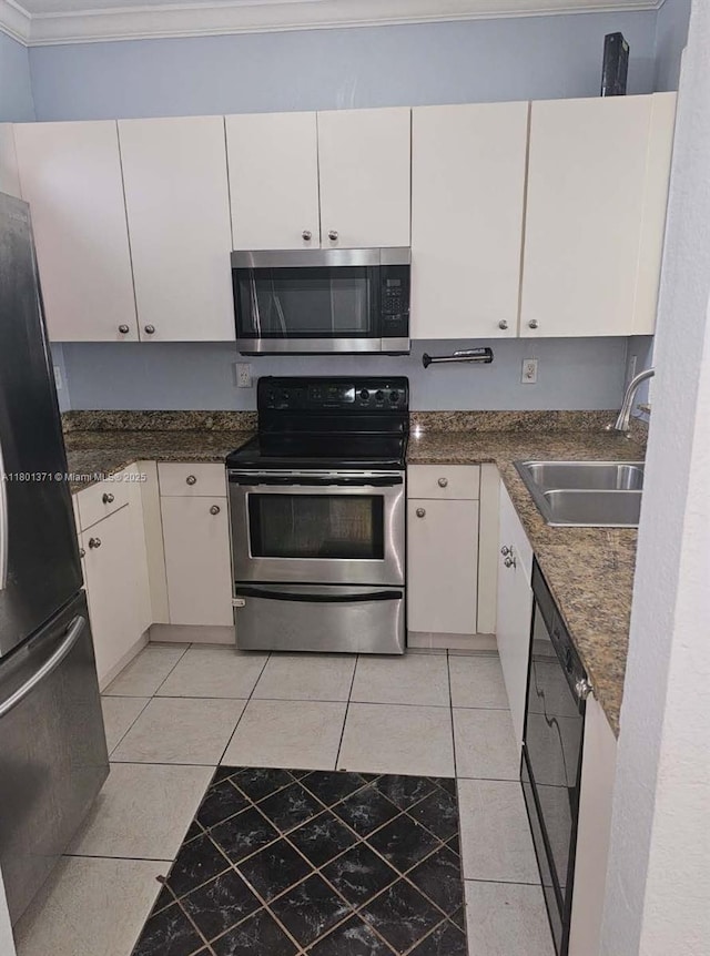 kitchen featuring black appliances, a sink, ornamental molding, white cabinets, and light tile patterned flooring