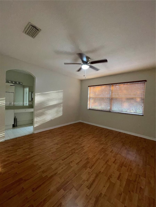 12708 SW 49th Dr, Miramar, FL 33027 - spare room featuring light wood-style floors, ceiling fan, baseboards, and arched walkways