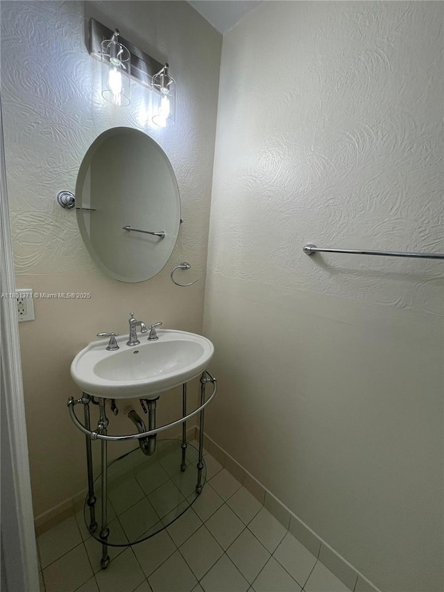 bathroom with tile patterned floors, baseboards, and a sink