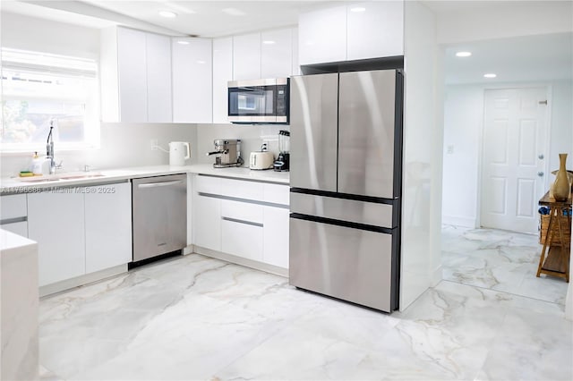 1649 NE 8th Ave, Fort Lauderdale, FL 33305 - kitchen with appliances with stainless steel finishes, modern cabinets, white cabinetry, light marble finish flooring, and recessed lighting