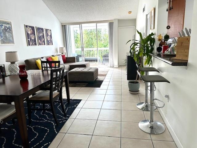 4632 NW 97th Pl Unit 262, Doral, FL 33178 - living area featuring light tile patterned floors, a textured ceiling, and vaulted ceiling