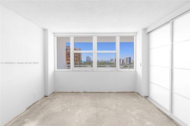 2030 S Ocean Dr Unit 1708, Hallandale Beach, FL 33009 - empty room with a textured ceiling, a skyline view, and unfinished concrete floors