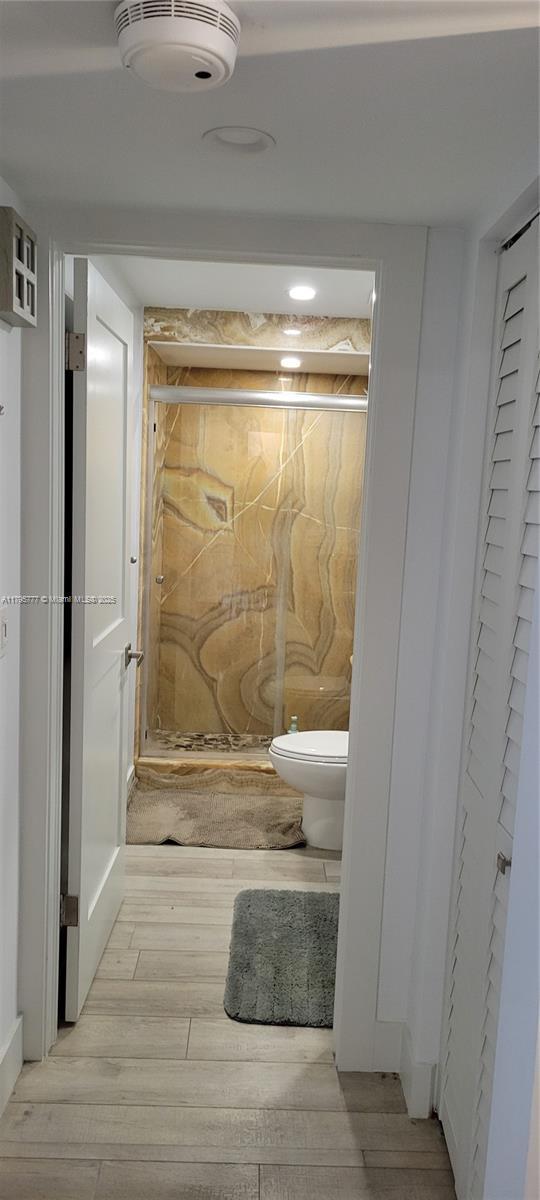 3040 Lake Shore Dr, Riviera Beach, FL 33404 - bathroom with wood finished floors, toilet, and a closet