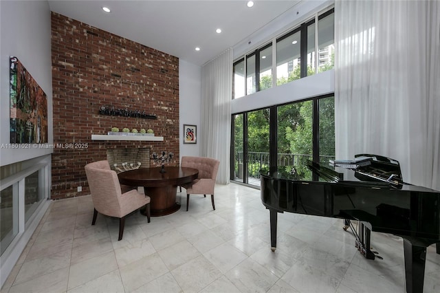 1530 NE Quayside Ter Unit A1, Miami, FL 33138 - sitting room featuring a towering ceiling, healthy amount of natural light, recessed lighting, and brick wall