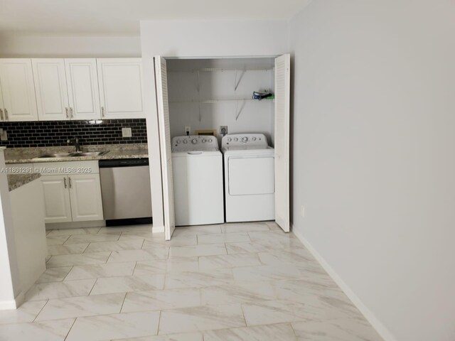 637 Executive Center Dr Unit N102, West Palm Beach, FL 33401 - clothes washing area featuring baseboards, light marble finish floors, and washing machine and dryer