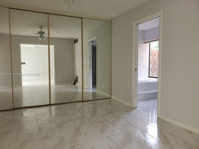 637 Executive Center Dr Unit N102, West Palm Beach, FL 33401 - unfurnished bedroom with light marble finish floors, a closet, and baseboards