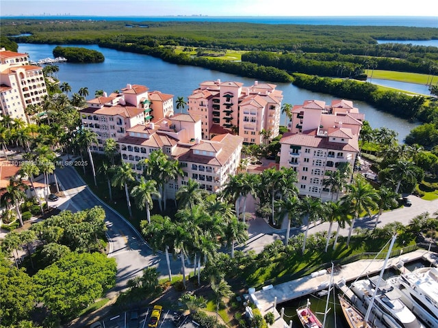 aerial view of a nearby body of water, apartment complex / building, and a forest