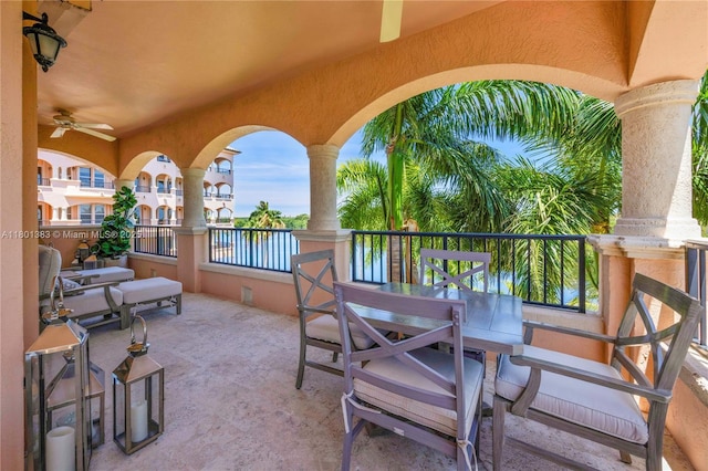 view of patio / terrace with a water view, a balcony, and a ceiling fan