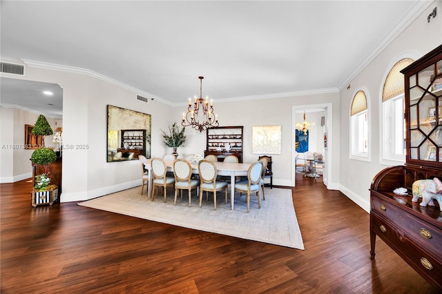 dining area featuring a chandelier, wood finished floors, baseboards, and crown molding