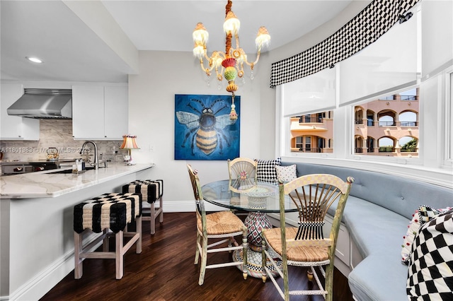 dining area featuring dark wood-style floors, breakfast area, baseboards, a chandelier, and recessed lighting