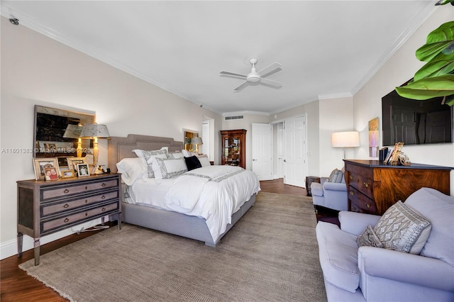 bedroom featuring wood finished floors, crown molding, baseboards, and a ceiling fan
