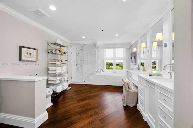 full bath featuring ornamental molding, a shower stall, vanity, wood finished floors, and recessed lighting
