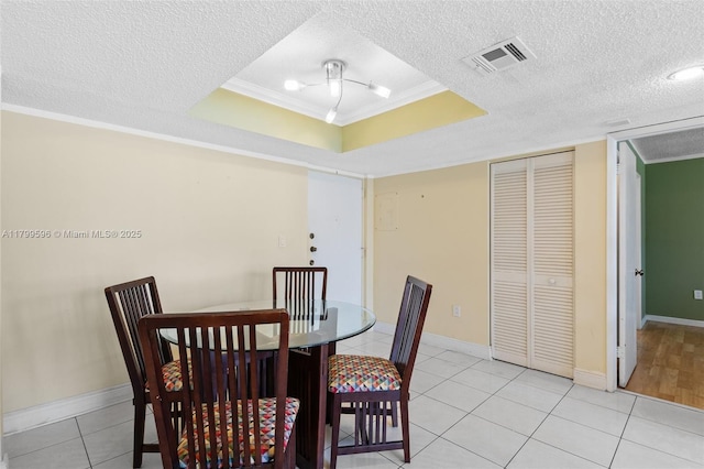 dining space with ornamental molding, light tile patterned flooring, a textured ceiling, and baseboards