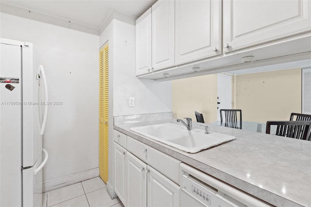 laundry room featuring a sink, light tile patterned flooring, and baseboards