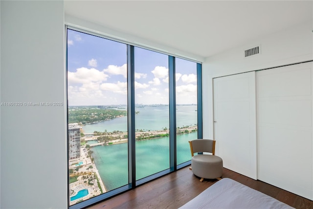 3131 NE 7th Ave Unit 3606, Miami, FL 33137 - bedroom with a wall of windows, a water view, wood finished floors, and a closet