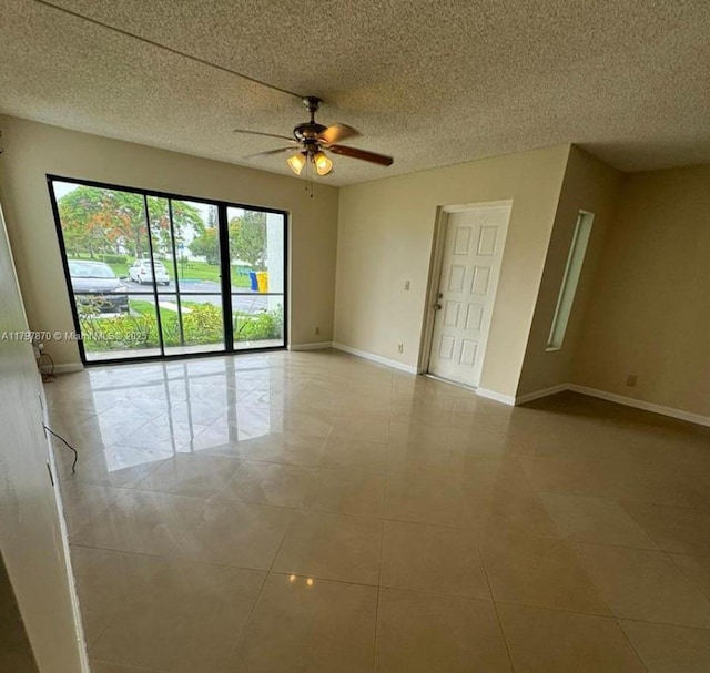 3664 Alder Dr Unit B1, West Palm Beach, FL 33417 - empty room featuring a ceiling fan, baseboards, light tile patterned flooring, and a textured ceiling